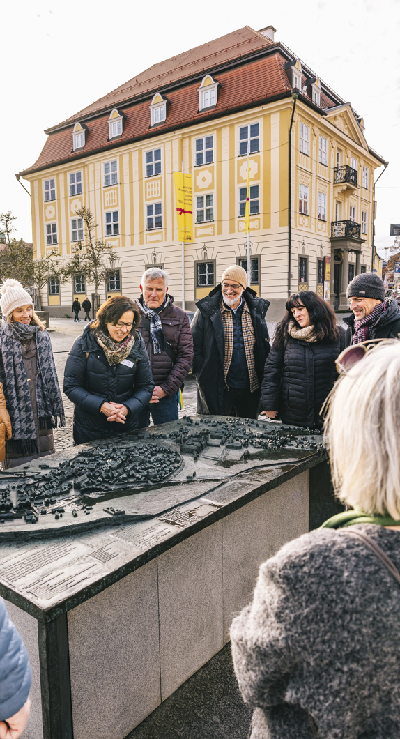 Stadtführerin zeigt ihrer Gruppe das Stadtrelief