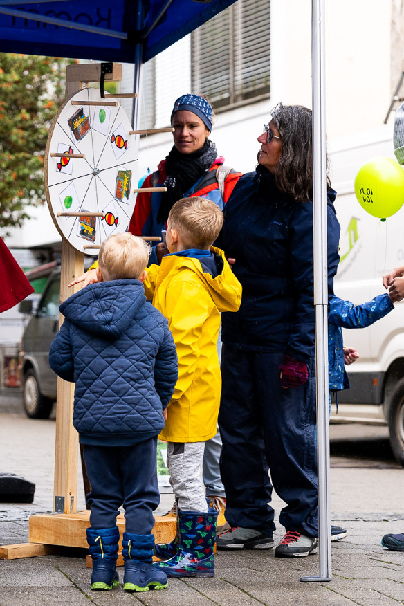 Kinder und Erwachsene stehen an einem Glücksrad - Copyright: Niko Spettmann