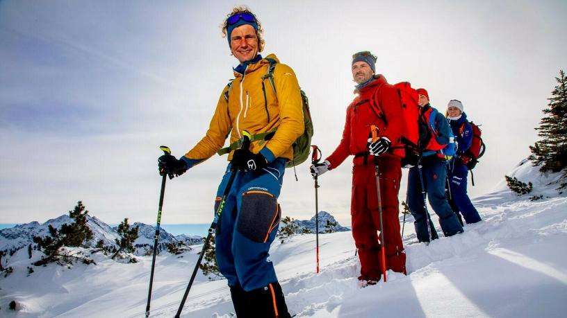 Eine Gruppe beim Schneeschuhwandern in den Bergen