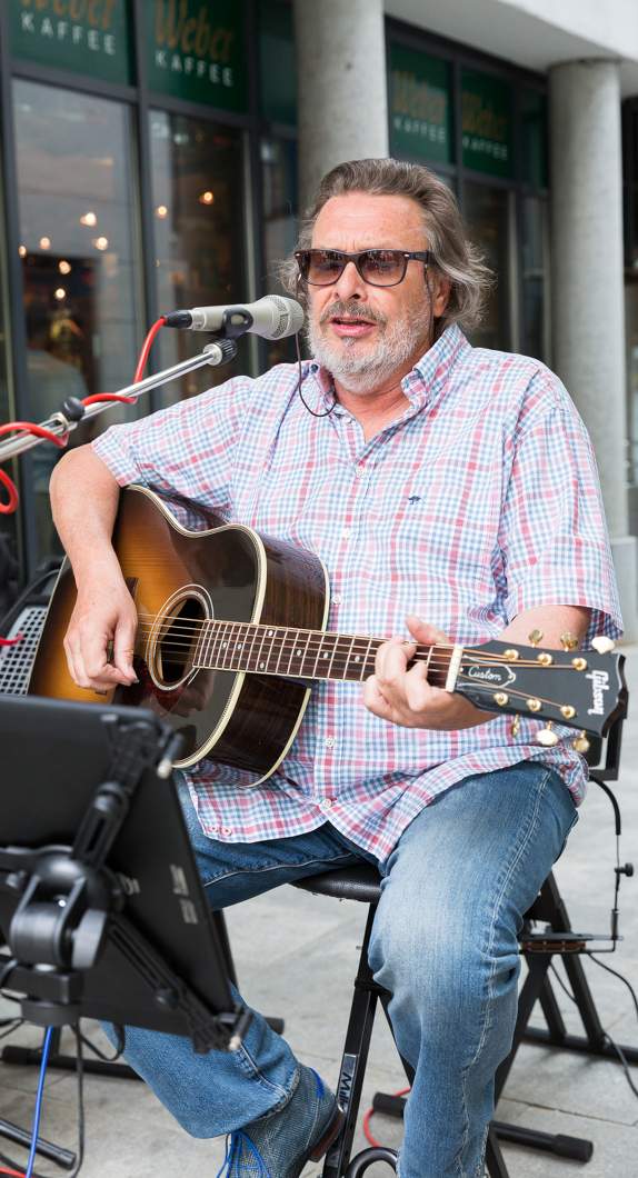 Mann spielt Gitarre in der Kemptener Innenstadt bei dem Tag der Musik