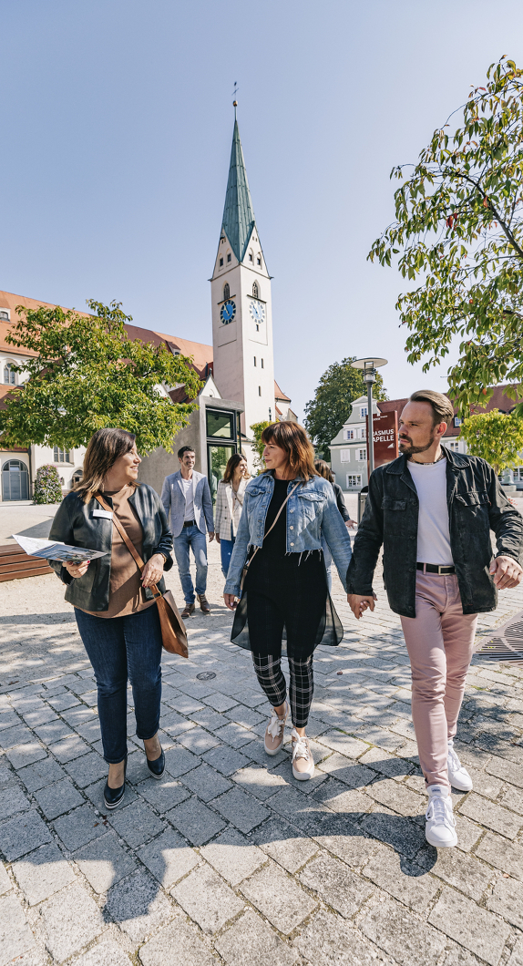 Eine kleine Stadtführungsgruppe läuft über den St-Mang-Platz.