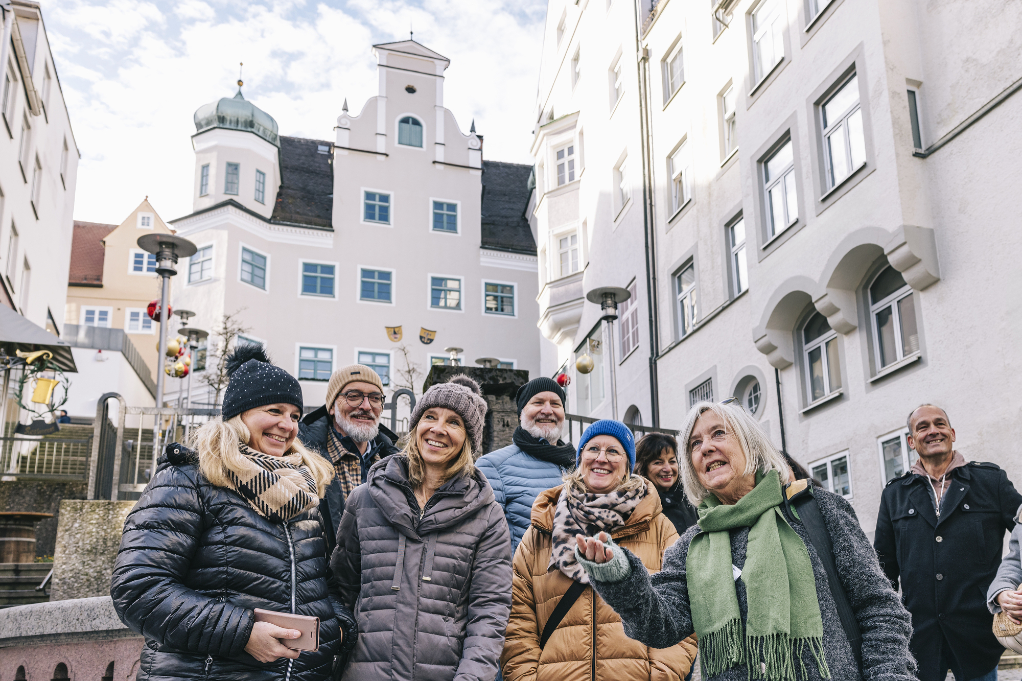 Menschengruppe hört einer Stadtführerin zu